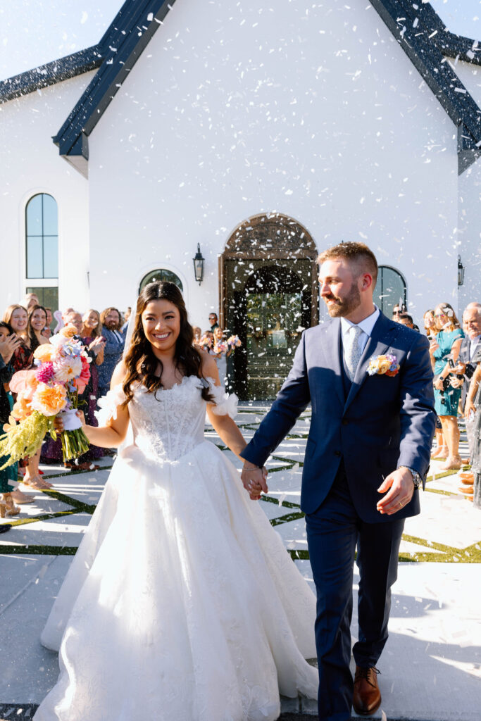 Bride and groom exit to confetti at their Arkansas wedding